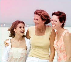 Imagem de três mulheres abraçadas, uma mais jovem à esquerda e duas mais velhas à direita.